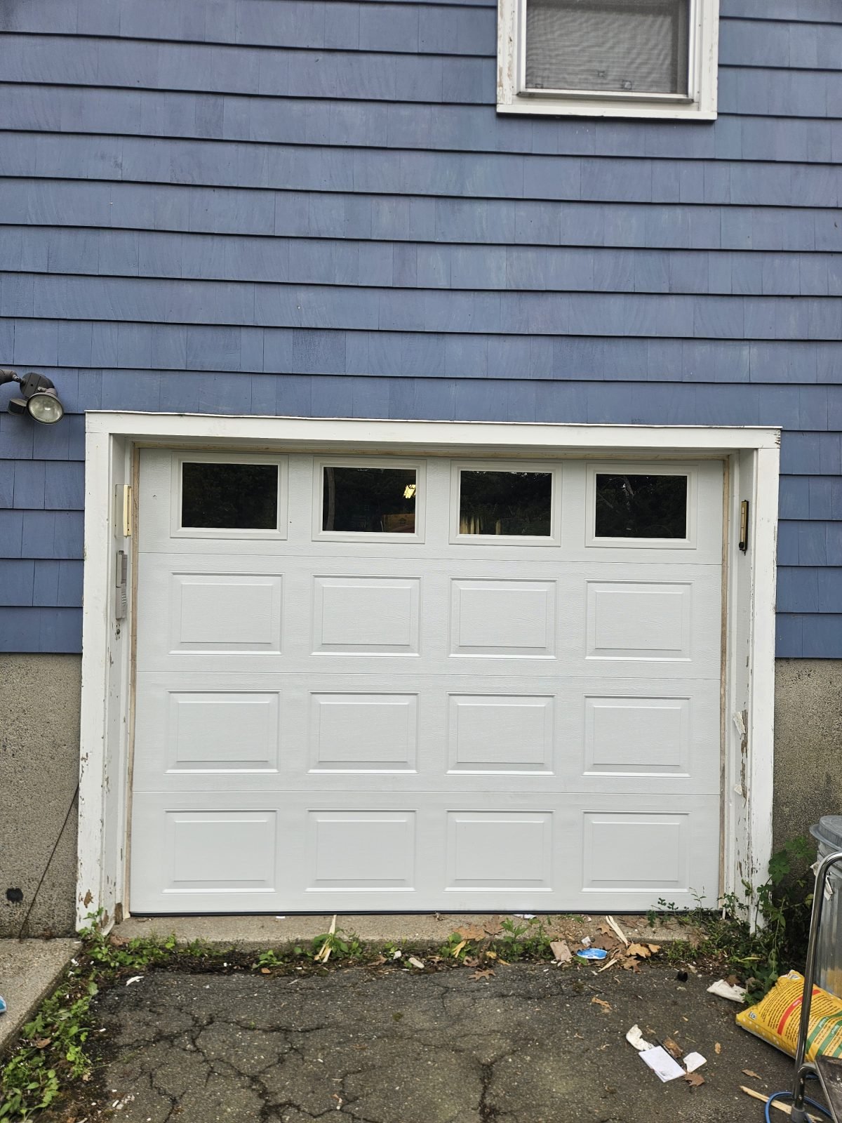 Newly installed white residential garage door on a home in Massachusetts