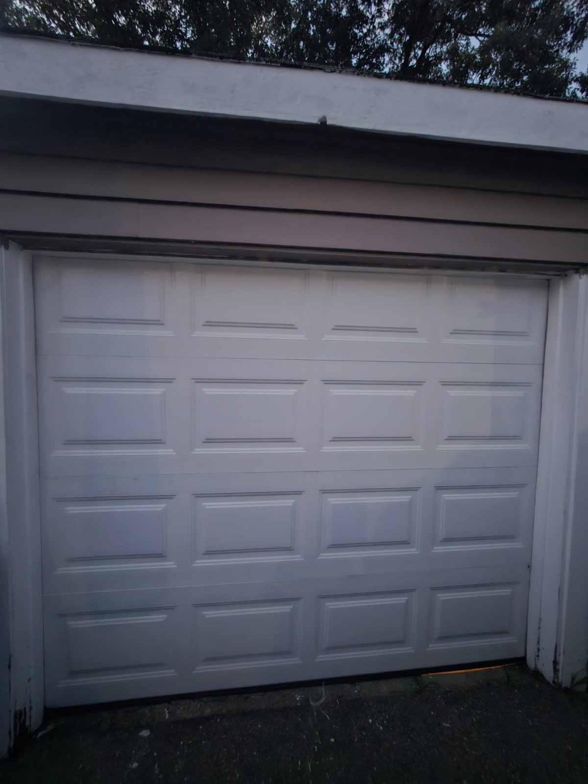 New white raised-panel garage door installed in the same opening