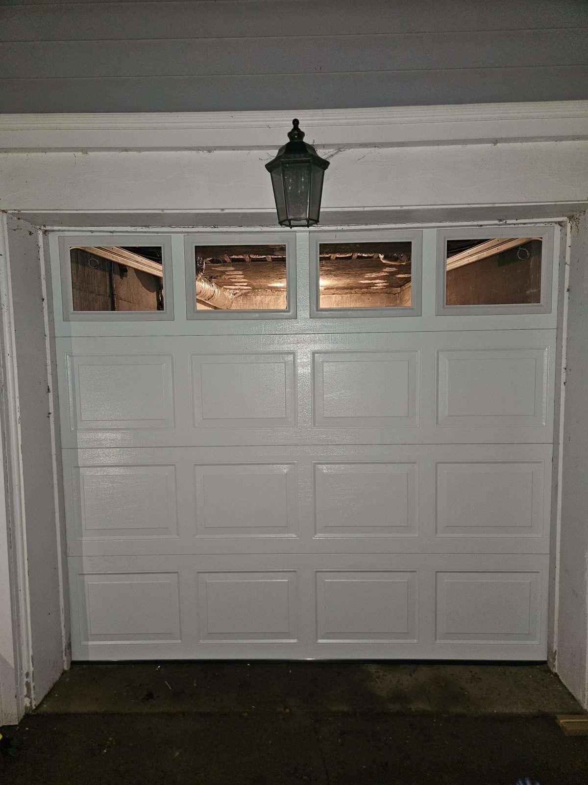 New white raised-panel garage door with windows installed